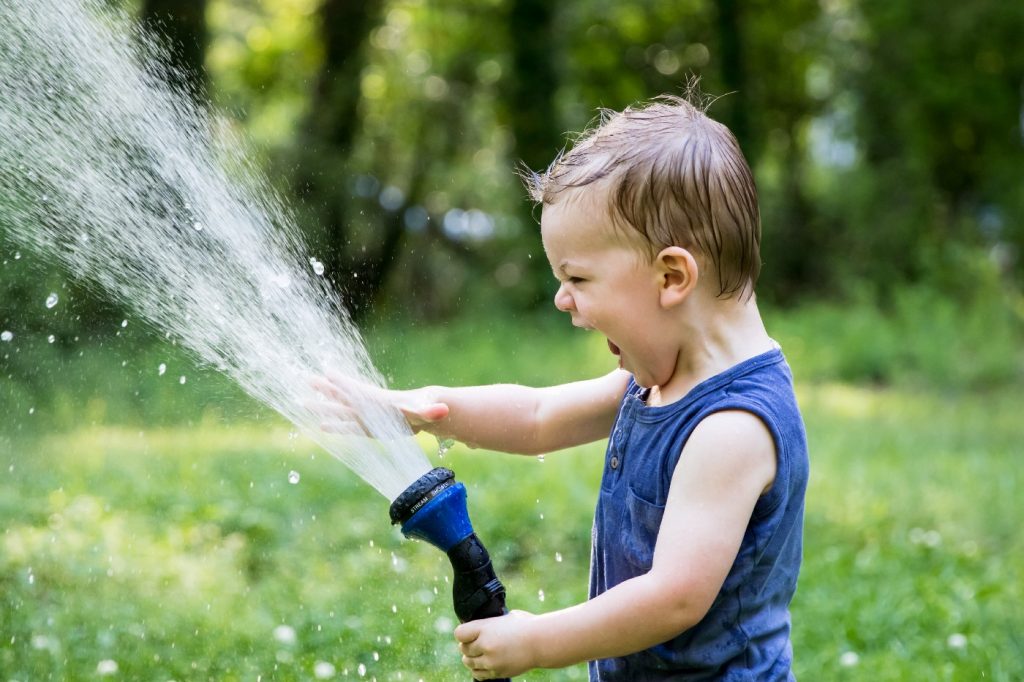 Toddler Playing with Watering Hose