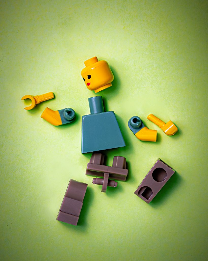Lego figure in pieces representing breaking problems down into first principles